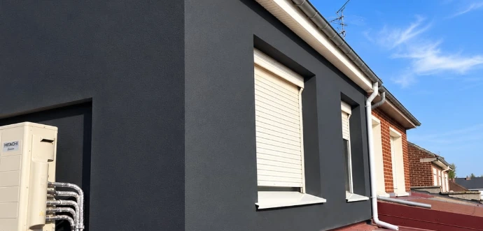 Rénovation de façade extérieure avec finition d'enduit et encadrements de fenêtres